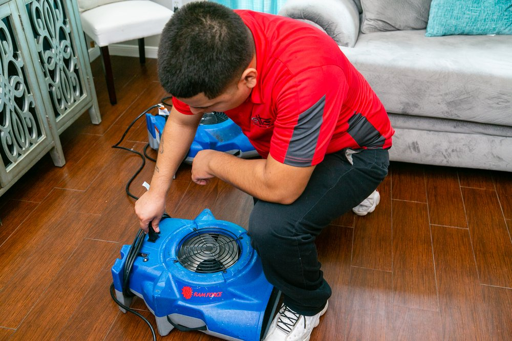 Erick Ashe, owner / operator of Elite Emergency Solutions, setting up drying equipment after water damage